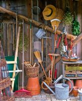 Shed with tools, barrow, pots and bunches of herbs hung up to dry