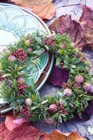 Evergreen wreath on table with autumn leaves
