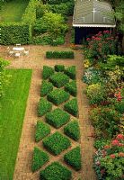 This city garden in the Netherlands is divided into thirds. A geometric treatment of Buxus and brick down the centre is boardered on one side by a lawn and the other by a colourful perennial boarder. 