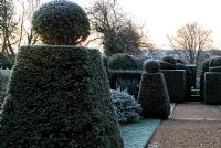 Succession of formal cut yew, with view down into the brick garden - Kingston Maurward Gardens, Dorchester, Dorset
