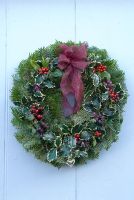 Pine foliage Christmas wreath with holly, red and purple berries