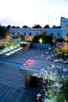 Decked terrace at night with led lighting and blue glass gravel - Roof garden, Holland Park, London