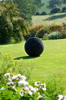 The Kernal sculpture on lawn in summer at Pettifers Garden, Oxfordshire