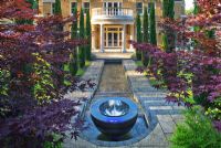 Chalice well water feature with waterfall, rill and house in background