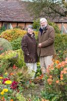 Carol and Malcolm Skinner in their garden in Autumn at Eastgrove Cottage garden, Worcestershire