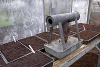 Paraffin heater in greenhouse with newly planted seeds in trays in early Spring