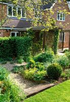 The staged pergola and hedge planting divide the space in this diffiuclt shaped garden
