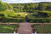 Looking down from the main house over the formal gardens with lime hedges, gravel paths, box hedging, steps, planters and pond area with arc of pleached lime trees - Gunnebo Slott, Sweden