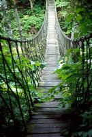 A rope bridge spans a deep ravine - Les Jardins de Quatre-Vents, Quebec 