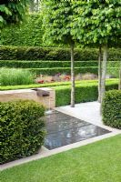 Water feature, clipped hedges and planting including Calamagrostis x acutiflora 'Karl Foerster' - The Laurent-Perrier Garden, Sponsored by Champagne Laurent-Perrier - Gold medal winner at RHS Chelsea Flower Show 2009