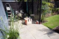 Utility area behind screen in garden with bike and garden waste bag - Small urban garden in London - 