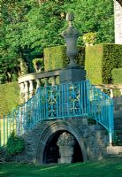 Belvedere opposite house with turquoise painted wrought iron railing. Bowl of fruit statue in alcove is a memorial to 'Pennant' Clough Willis-Ellis' dog - Plas Brondanw