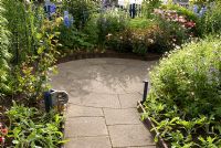 Path and front garden borders with Polemonium, Geranium endressi, Rosa 'Sweet Dream', Delphinium 'Sky Blue'and Tanacetum ' Robinson's Mix' 
