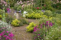 Scented Garden with ornate sundial with butterfly feature, paved pathways and scented bush roses and herbaceous perennials in borders - Woodpeckers, Warwickshire