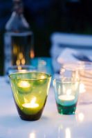 Nightlights in glass holders on garden table