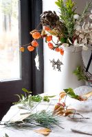 Christmas foliage with enamel jug with dried flowers and foliage from the garden in Winter