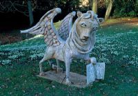 Griffin on the Bowling Green with snowdrops behind - Painswick Rococo Garden, Painswick, Gloucestershire in February