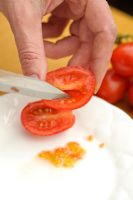 Step by step of saving tomato seeds - Scraping seeds from ripe tomato