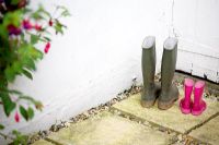 Adult and child Wellington boots next to garden shed