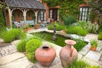 Patio area with pond and fountain, seating area with plantings of aromatic lavender and terracotta pots and containers - Wilkins Pleck, NGS, Whitmore near Newcastle-under-Lyme in North Staffordshire 