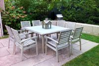 Outdoor table and chairs on stone paving.
