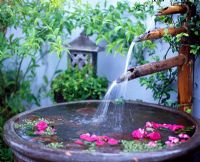 Water feature with triple bamboo spouts and urn.