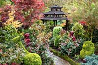 Pagoda in Japanese style garden in autumn with Acers and many deciduous trees, shrubs and conifers grown for their foliage, some showing stunning autumnal tints and hues - Four Seasons Garden NGS, Walsall, Staffordshire 