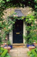 Front door with wrought iron porch and climbing Roses - New Square, Cambridge