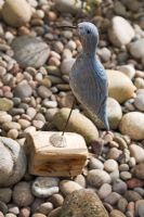Seaside Inspired garden. Carved decoy bird by Martin Scorey sits on the pebble beach