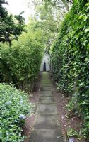 Path with focal point in suburban family garden for restored Art Deco house