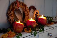 Apples used as tea-light or candle holders decorated with Ivy, dried orange slices and Star Anise.