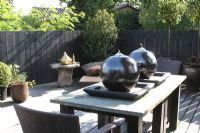 Large spherical oil burners on table on roof terrace in summer.