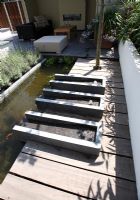 Urban garden in summer with three rectangular water features and large pond. Phyllostachys nigra- Bamboo in raised bed.