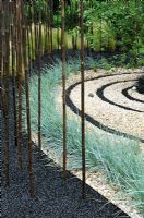 Contrasting circles of crushed black basalt and gravel with planting of Bamboo and Elymus magellanicus. Design - Sheena Seeks. RHS Tatton park flower show