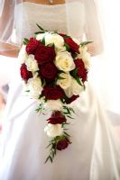 Bride holding a bouquet of red and white Roses