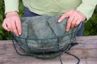 Planting up a hanging basket - lining a basket with fibre liner 