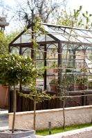 Reproduction victorian style glasshouse with rusted metal appearance to convey age.