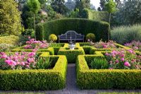 Roses growing in Buxus- Box parterre with sundial and bench backed by Taxus hedge
