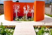 The H Garden with decking, orange rendered wall, white fake tree sculpture and planting of Cosmos, Marigolds and fennel - Future gardens, St Albans, Herts 