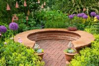Horseshoe seating area surrounded by flowerbeds - Planting includes Alchemilla mollis and Allium 'Globemaster'