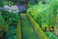 The herb garden, edged with Buxus- Box and planted with cottage garden plants. Town Place Garden, Sussex