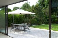 Contemporary urban garden with wooden decking and seating area - London