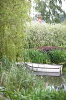 Westonbury Mill Water Gardens with boat on water near weeping willow