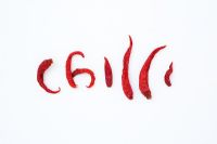 Capsicum - Dried red chillis spelling chilli on white background