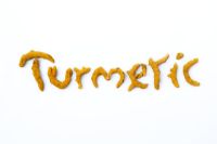 Curcuma Longa - Dried Turmeric rhizomes spelling tumeric on white backnground