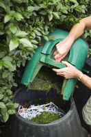 Emptying grass cuttings into compost bin