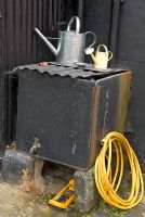 Rustic water conservation - Water tank, hose, sprinkler and watering cans