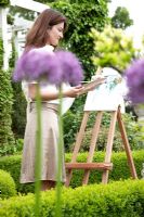 Woman painting in garden 