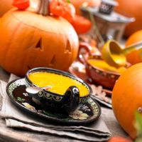 Carved pumpkins and pumpkin soup on a table 