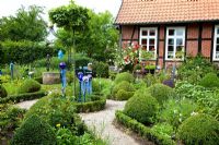 Cottage garden with clipped box, gravel paths and glass ornaments 